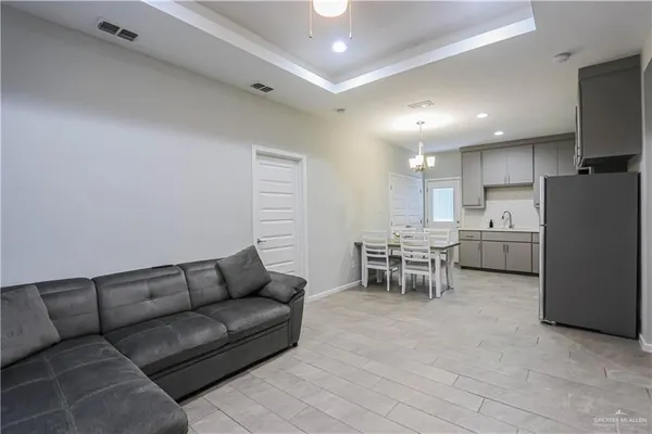 a living room with furniture with kitchen view and a couch