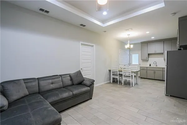 a living room with furniture and a dining table with kitchen view