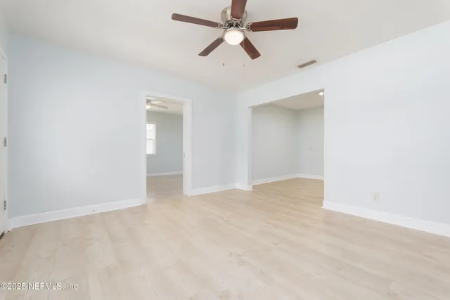 an empty room with chandelier fan