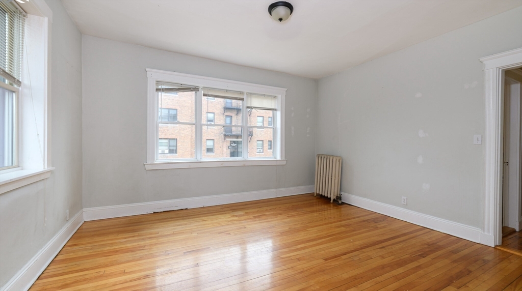 an empty room with a hardwood and windows