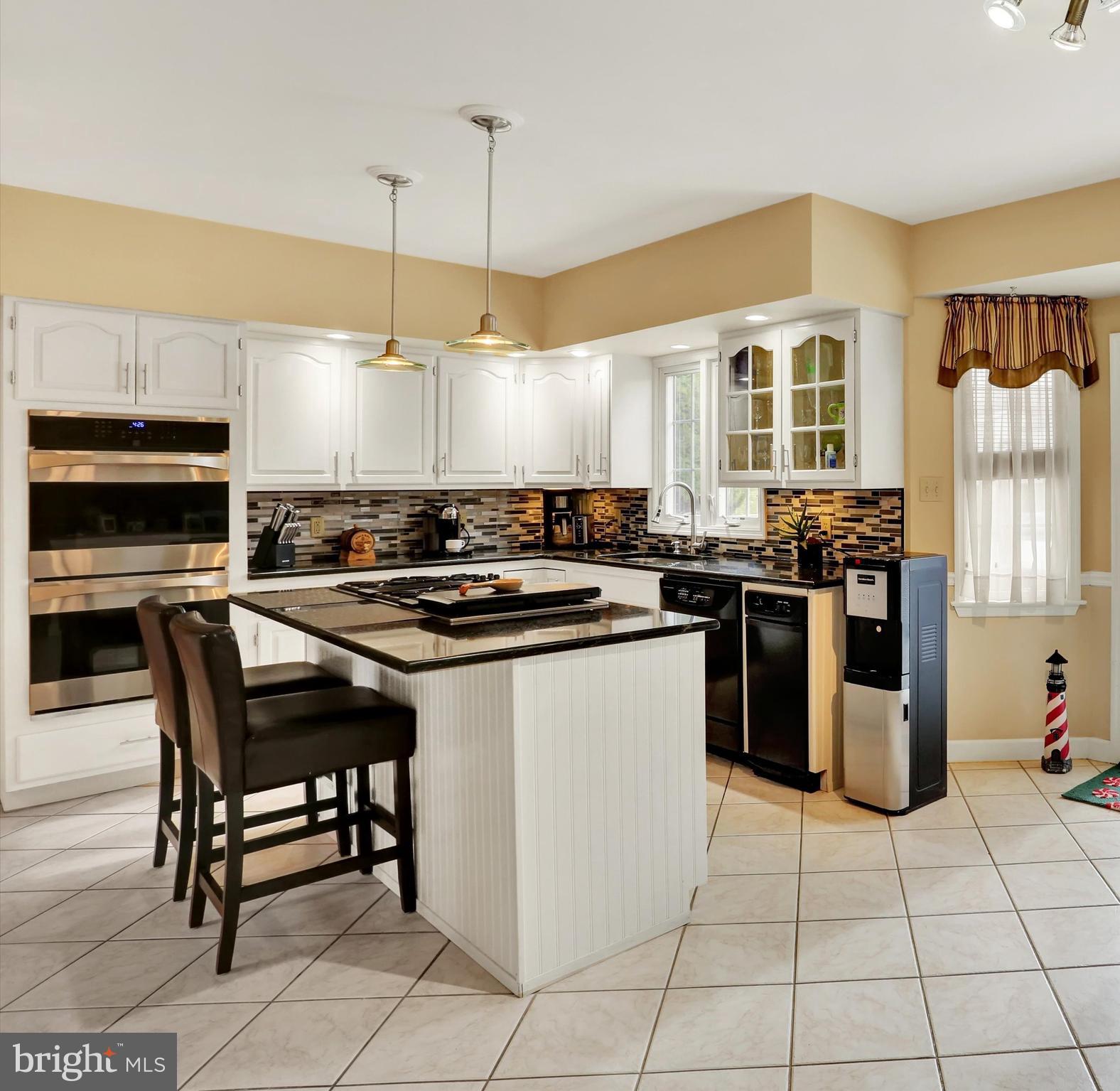 6 Virginia Avenue Sinking Spring, PA 19608 - Photo 10 of 30 a kitchen with stainless steel appliances granite countertop a stove a sink a dining table and chairs