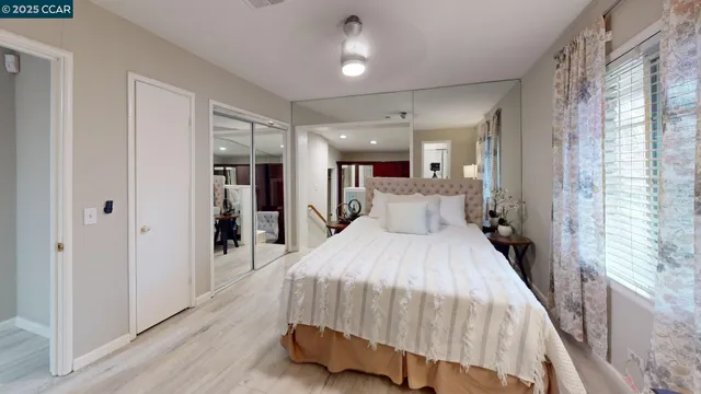 a spacious bedroom with a bed and a chandelier