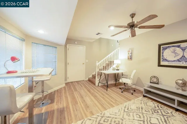 a living room with furniture potted plant and a large window