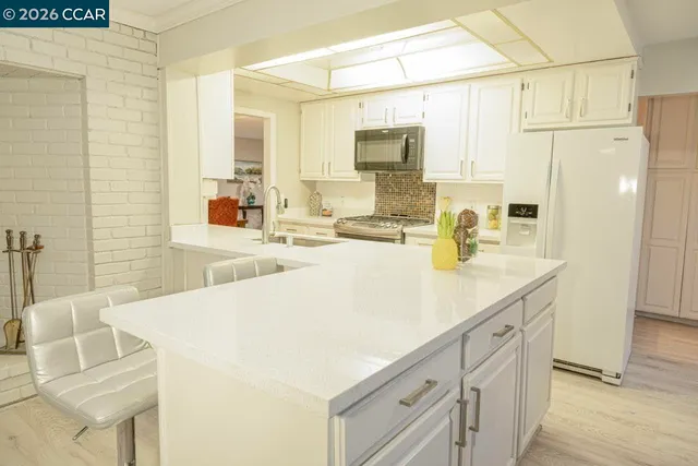 a kitchen with stainless steel appliances a sink microwave and cabinets