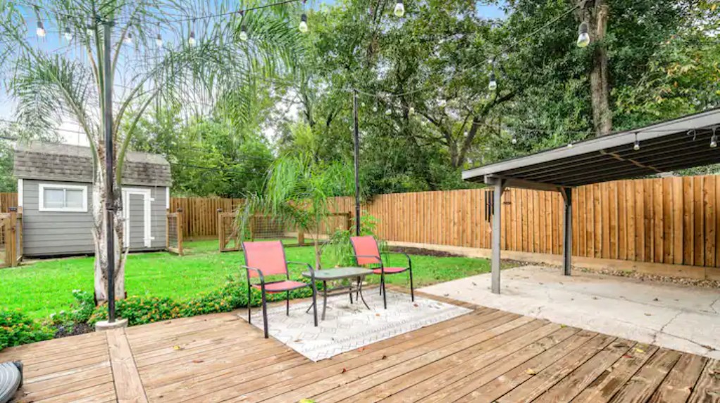 4709 Lido Lane Houston, TX 77092 - Photo 18 of 19 a patio with a table and chairs and potted plants with wooden floor and fence