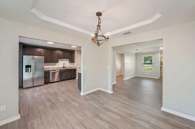 a view of a kitchen with a sink a ceiling fan and wooden floor