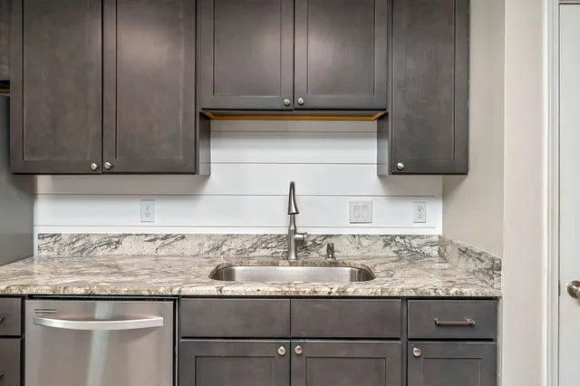 a kitchen with granite countertop cabinets and black stainless steel appliances
