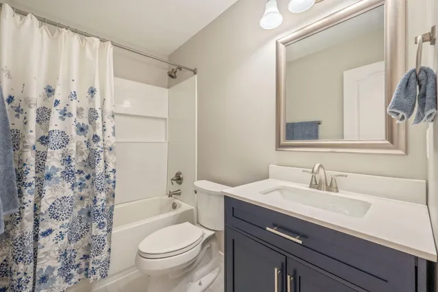 a bathroom with a sink a toilet and shower curtain