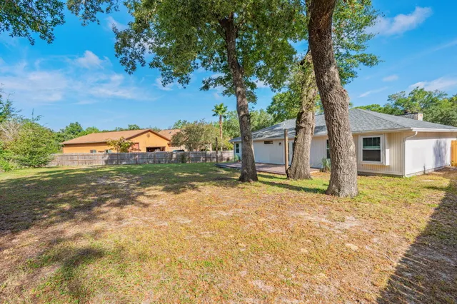 a view of a house with backyard and tree