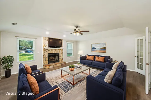 a living room with furniture fireplace and a large window