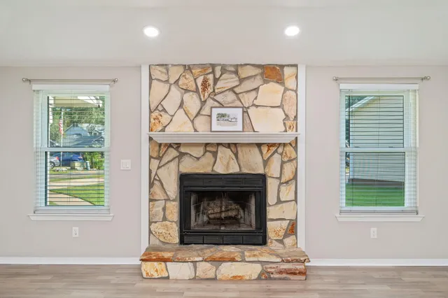 a living room with window and a fireplace