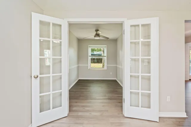 an empty room with wooden floor and windows
