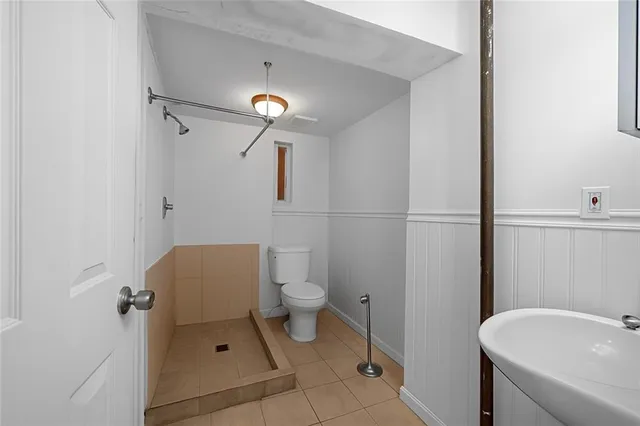 a bathroom with a toilet a sink and shower