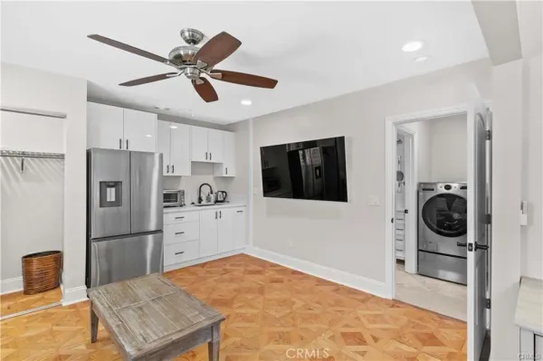 a kitchen with a refrigerator and white cabinets