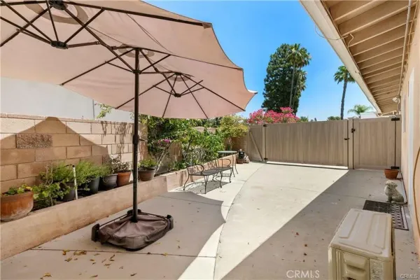 a view of a patio with a table and chairs under an umbrella