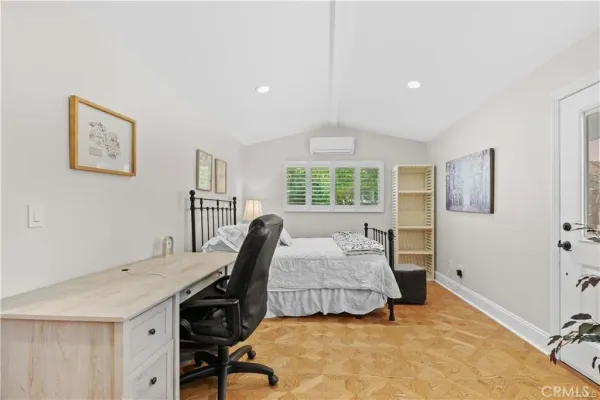 a bedroom with a bed and wooden floor