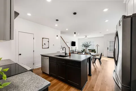 a kitchen with stainless steel appliances granite countertop a sink a stove and a refrigerator