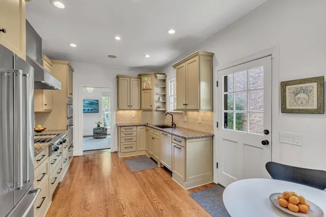a large kitchen with stainless steel appliances a lot of counter space and a wooden floor