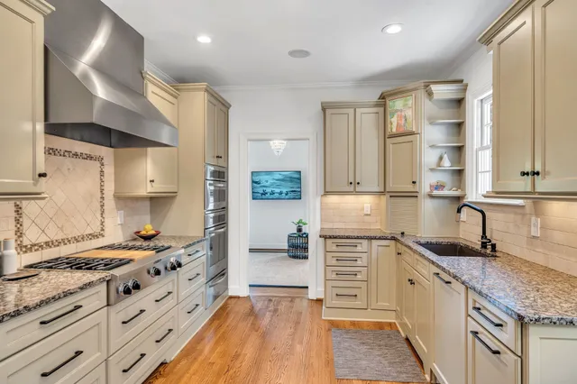 a kitchen with stainless steel appliances granite countertop a stove and a sink