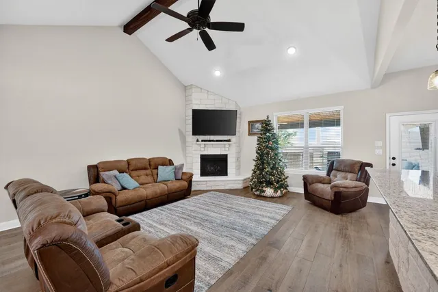 a living room with furniture a fireplace and a flat screen tv