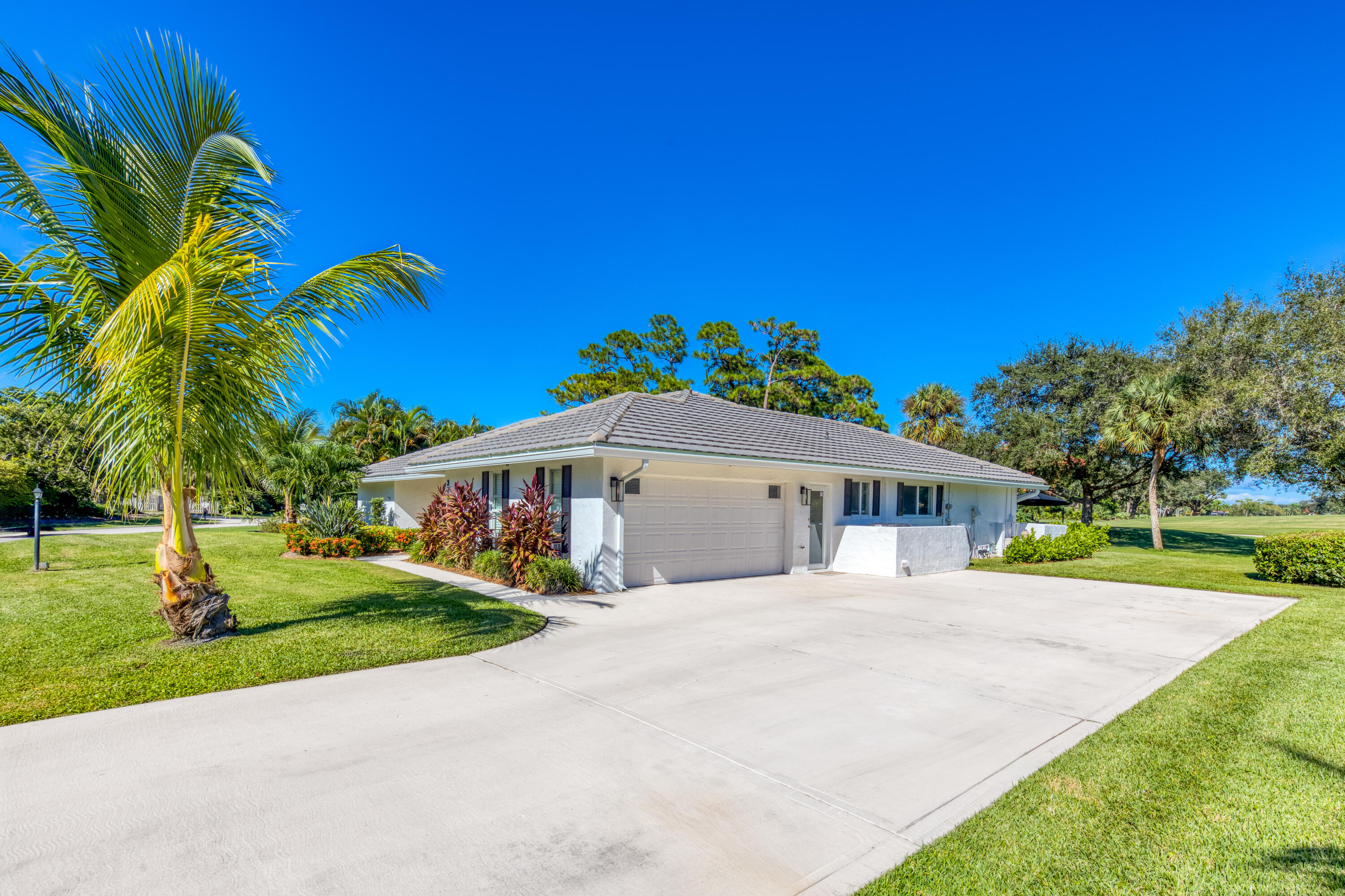 3771 Southeast Fairway West Stuart, FL 34997 - Photo 13 of 41 a front view of a house with a yard and trees