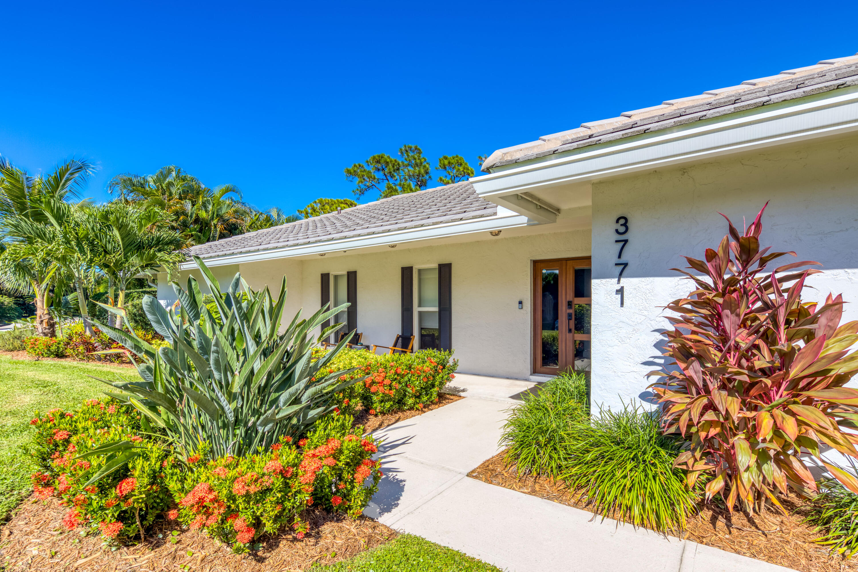 3771 Southeast Fairway West Stuart, FL 34997 - Photo 14 of 41 a front view of a house with a large tree