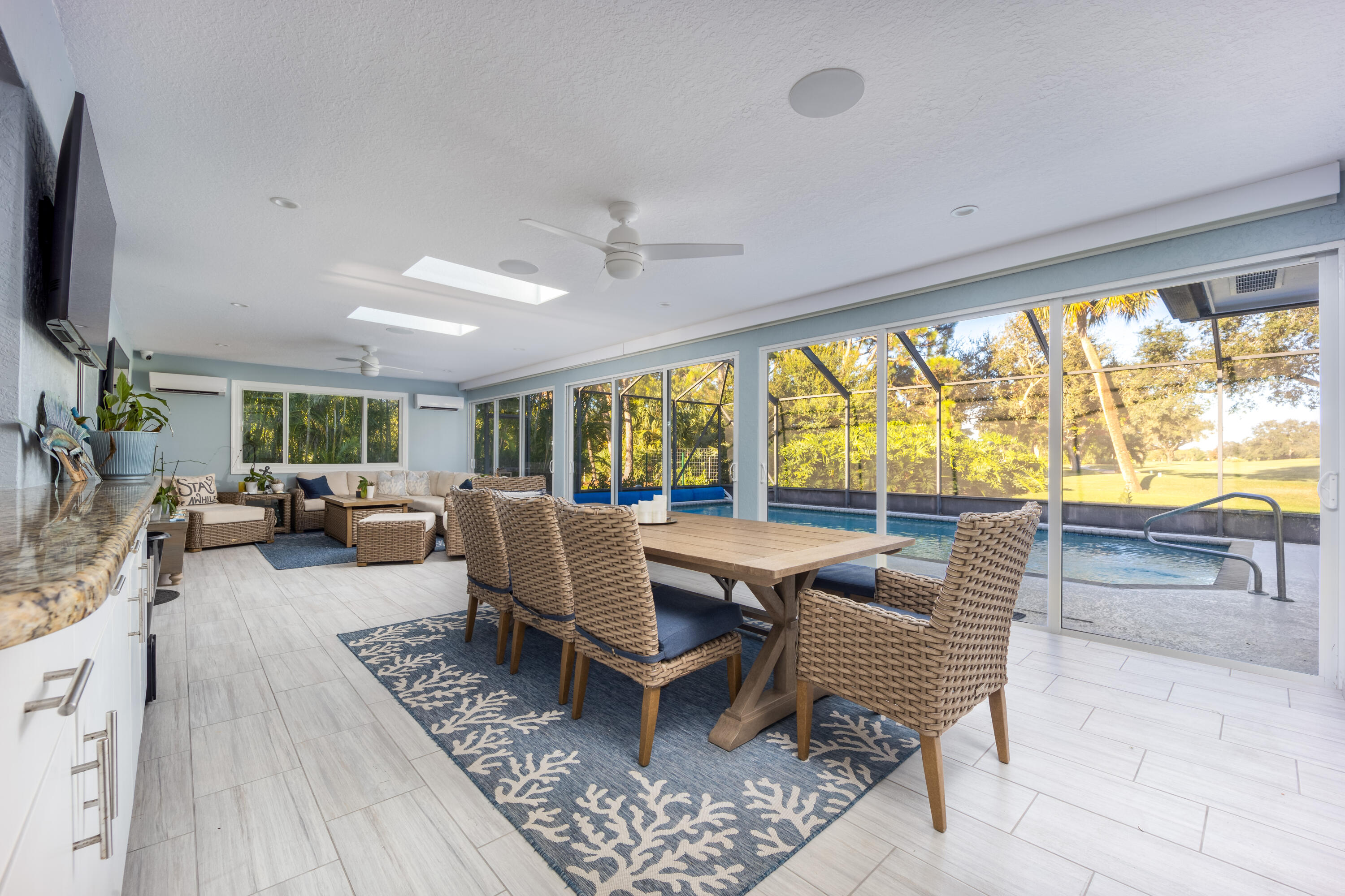 3771 Southeast Fairway West Stuart, FL 34997 - Photo 33 of 41 a living room with furniture a large window and a flat screen tv
