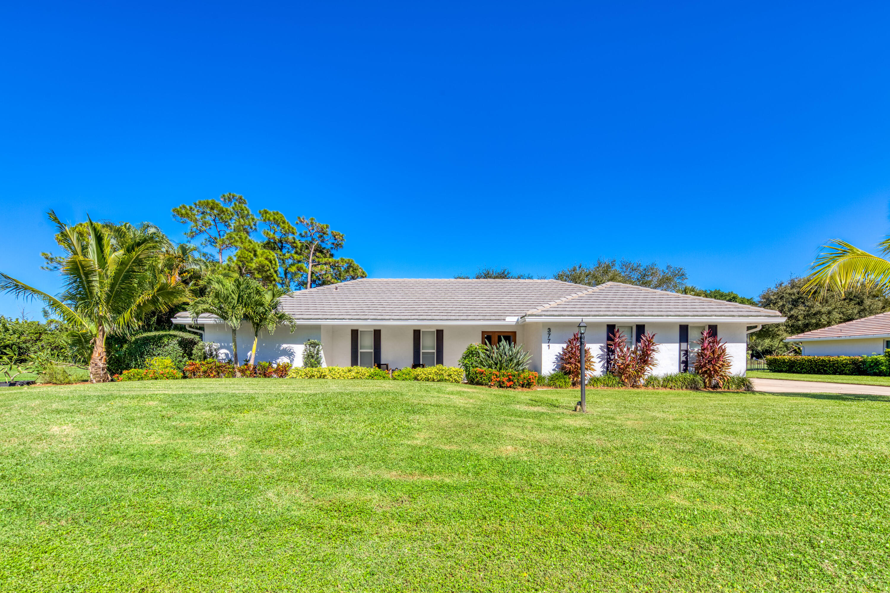 3771 Southeast Fairway West Stuart, FL 34997 - Photo 9 of 41 a front view of a house with a garden