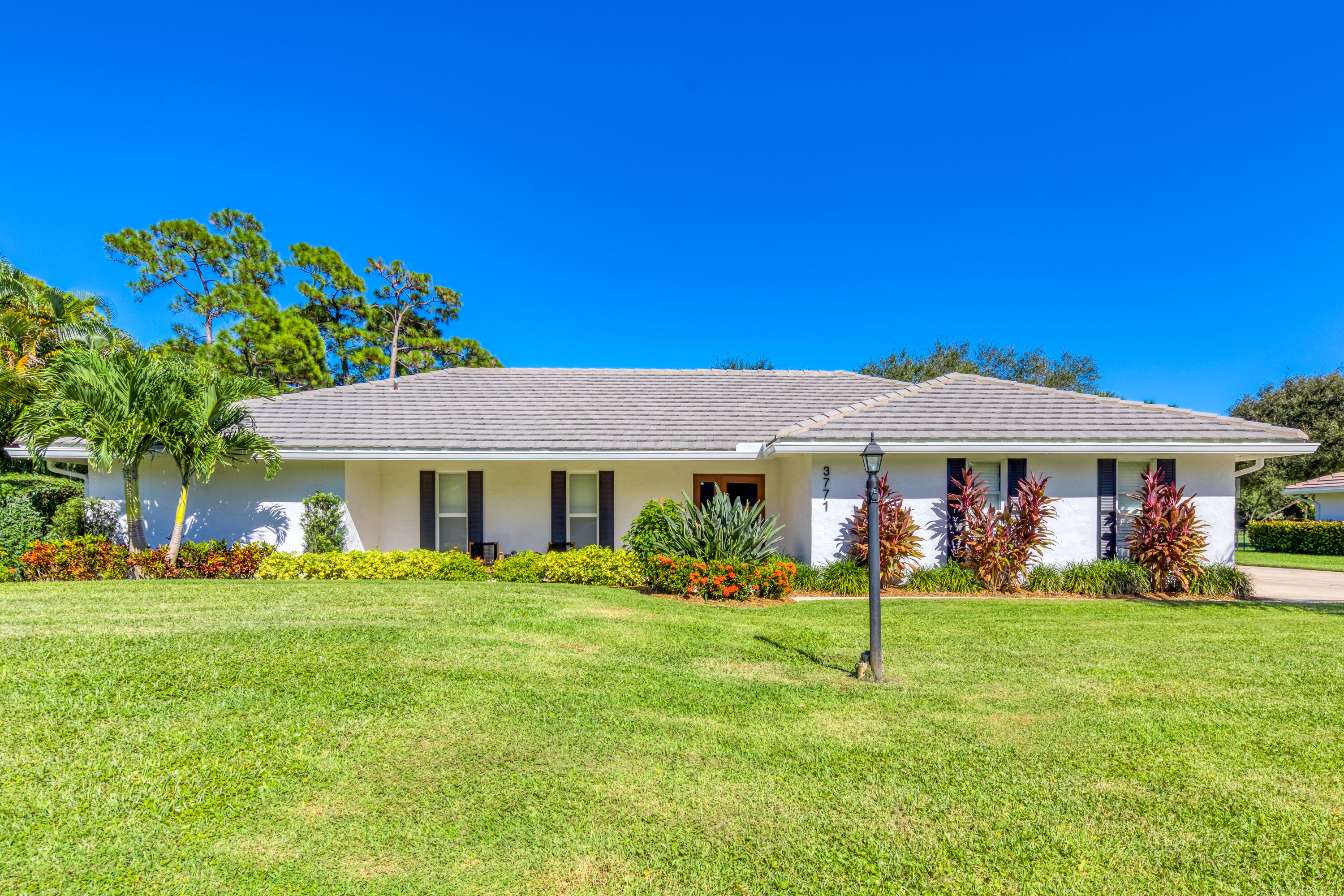 3771 Southeast Fairway West Stuart, FL 34997 - Photo 10 of 41 a front view of a house with a yard