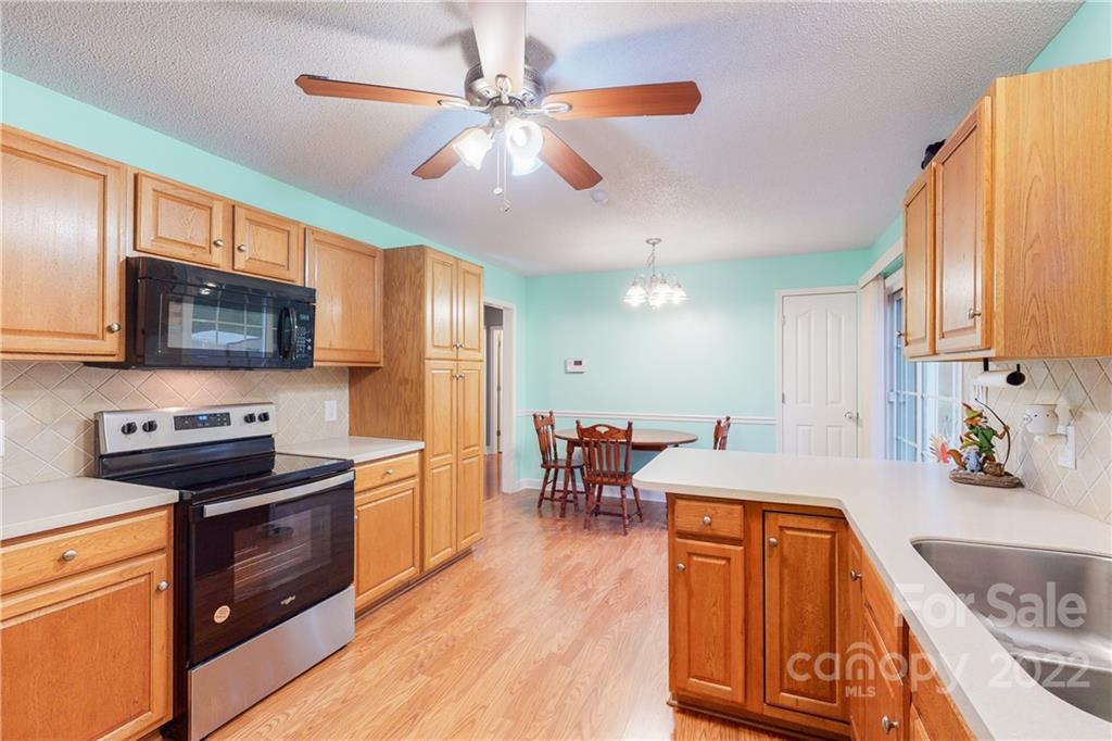 261 Pitts Road Catawba, SC 29704 - Photo 17 of 43 a kitchen with stainless steel appliances granite countertop a refrigerator a stove top oven a sink dishwasher and wooden cabinets with wooden floor