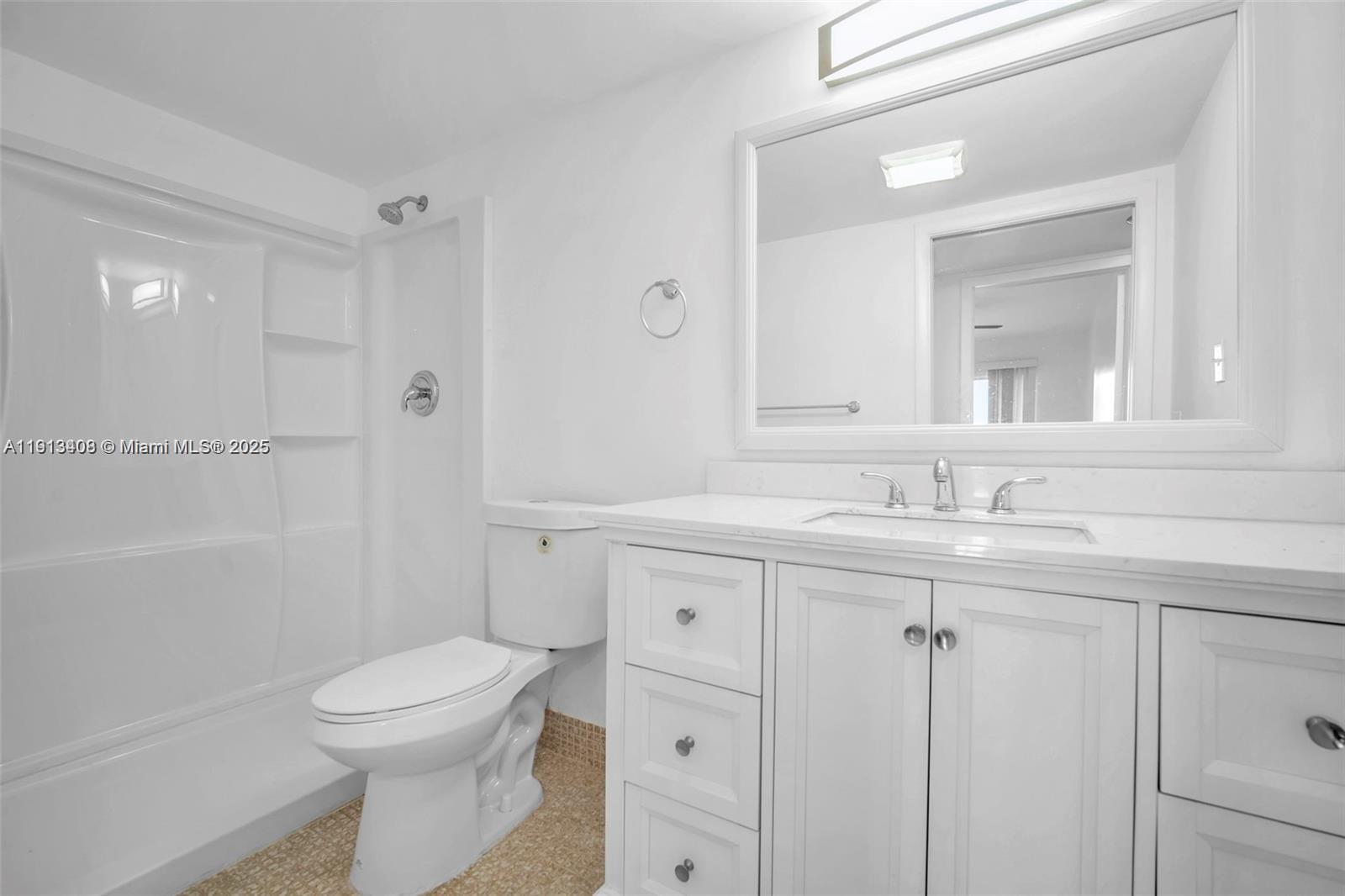 2048 Hythe A, Unit 2048 Boca Raton, FL 33434 - Photo 16 of 25 a bathroom with a toilet a sink a mirror and a shower