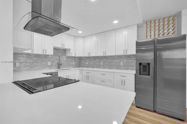 a kitchen with a refrigerator a sink a stove and cabinets