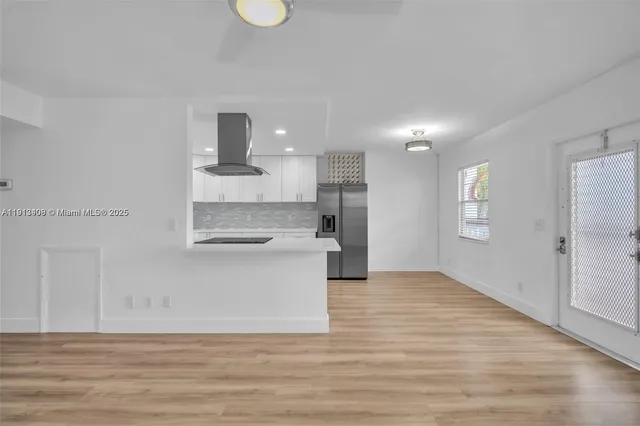 a view of kitchen with wooden floor and electronic appliances