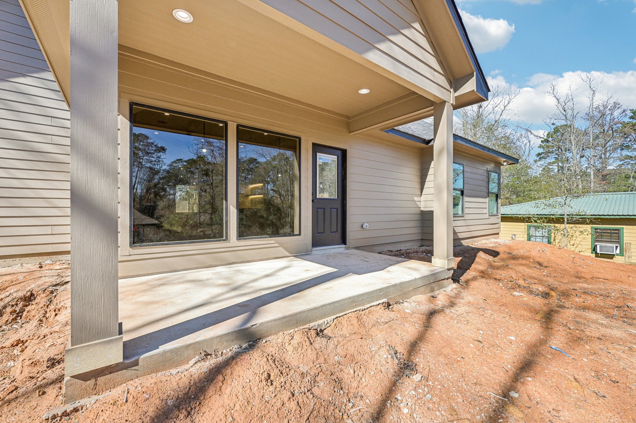 15132 Coaltown Road Willis, TX 77378 - Photo 27 of 29 Back patio with large windows, a covered area, and a sturdy design. The patio overlooks a natural setting, offering a serene outdoor space.