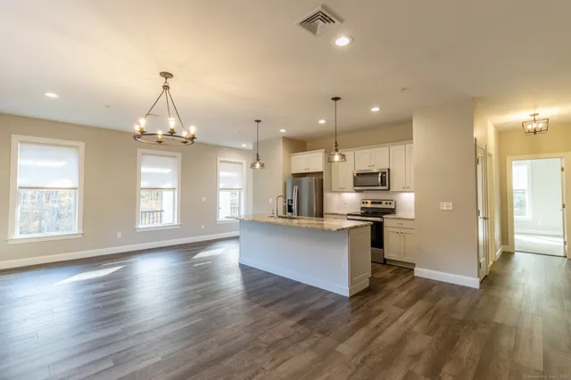 a view of kitchen with sink and refrigerator