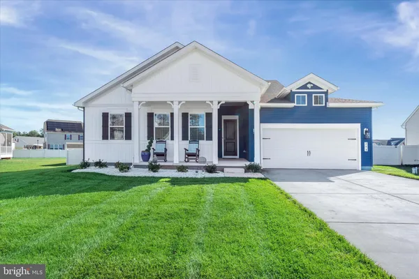 a front view of a house with yard and green space