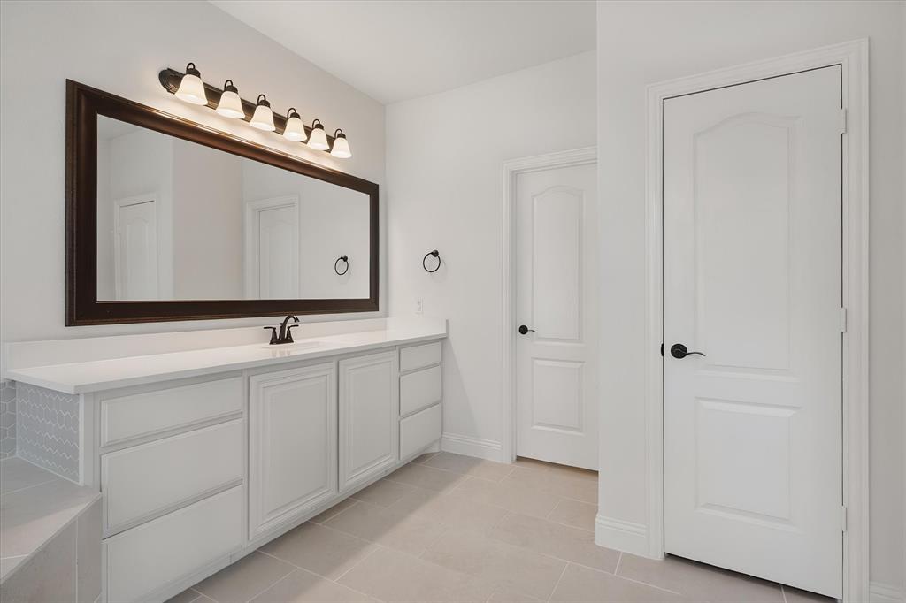 5626 Rutherford Drive Midlothian, TX 76065 - Photo 22 of 37 Here's the second vanity — plenty of counter and drawer space, plus doors leading to the water closet (private toilet door) and closet.
