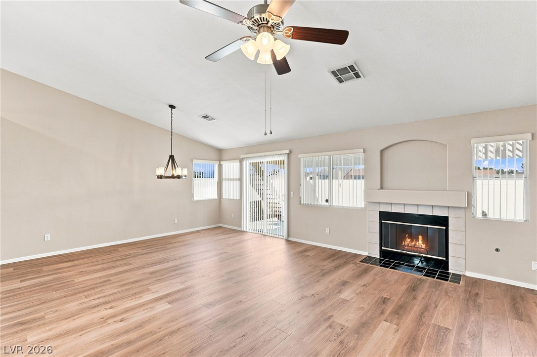 904 Shadowfax Road Henderson, NV 89015 - Photo 4 of 31 Rich wood flooring runs throughout this spacious living area, highlighted by a modern fireplace.