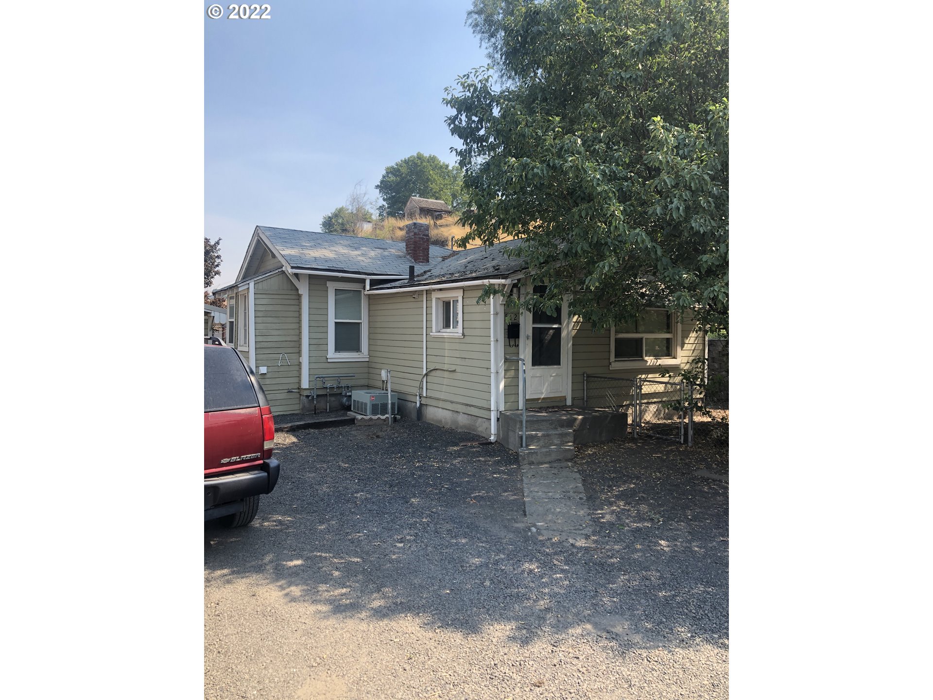 a backyard of a house with barbeque oven and outdoor seating