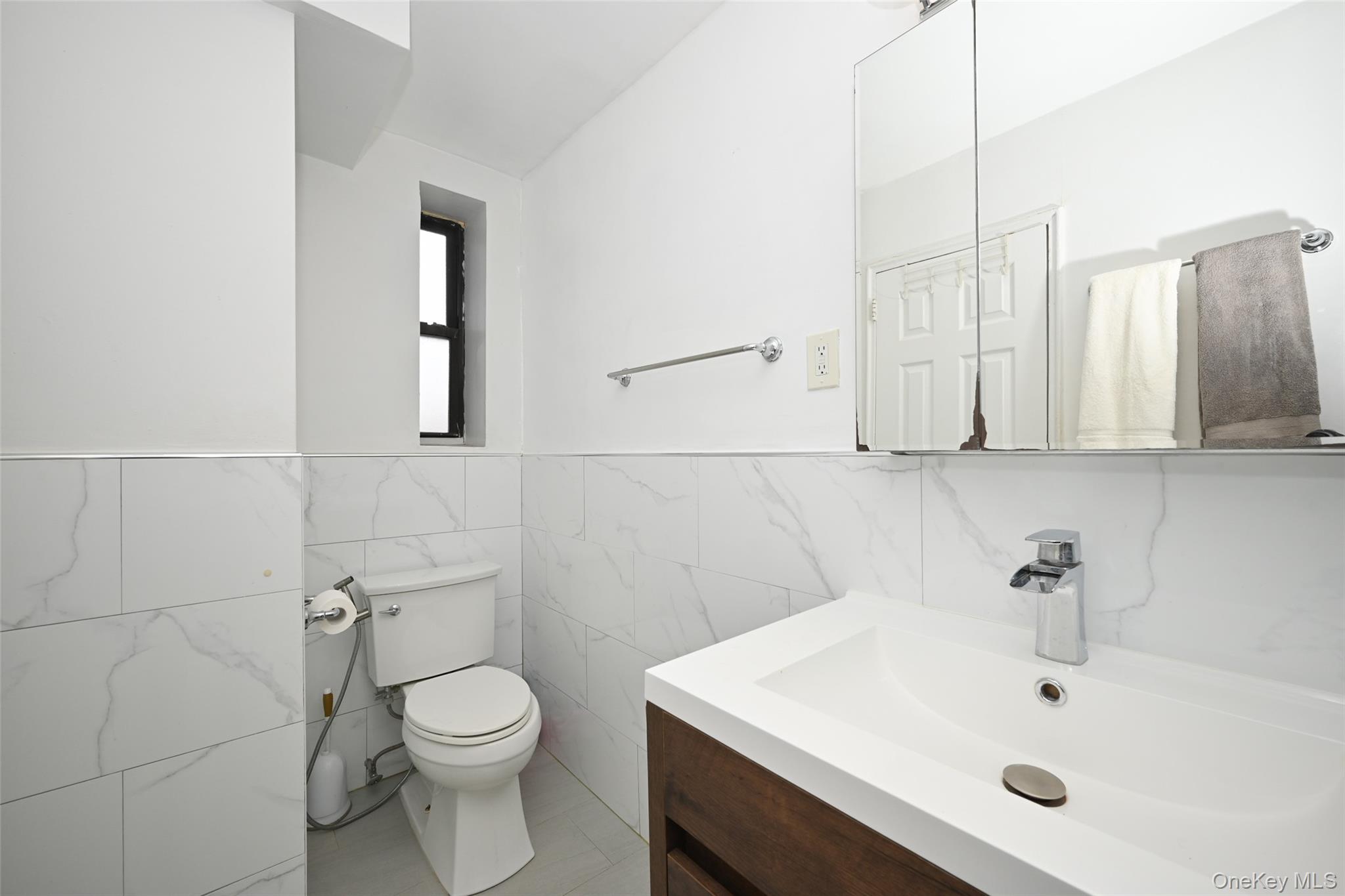 150-30 71st Avenue, Unit 2F Queens, NY 11367 - Photo 11 of 19 Bathroom featuring tile walls, vanity, and wainscoting