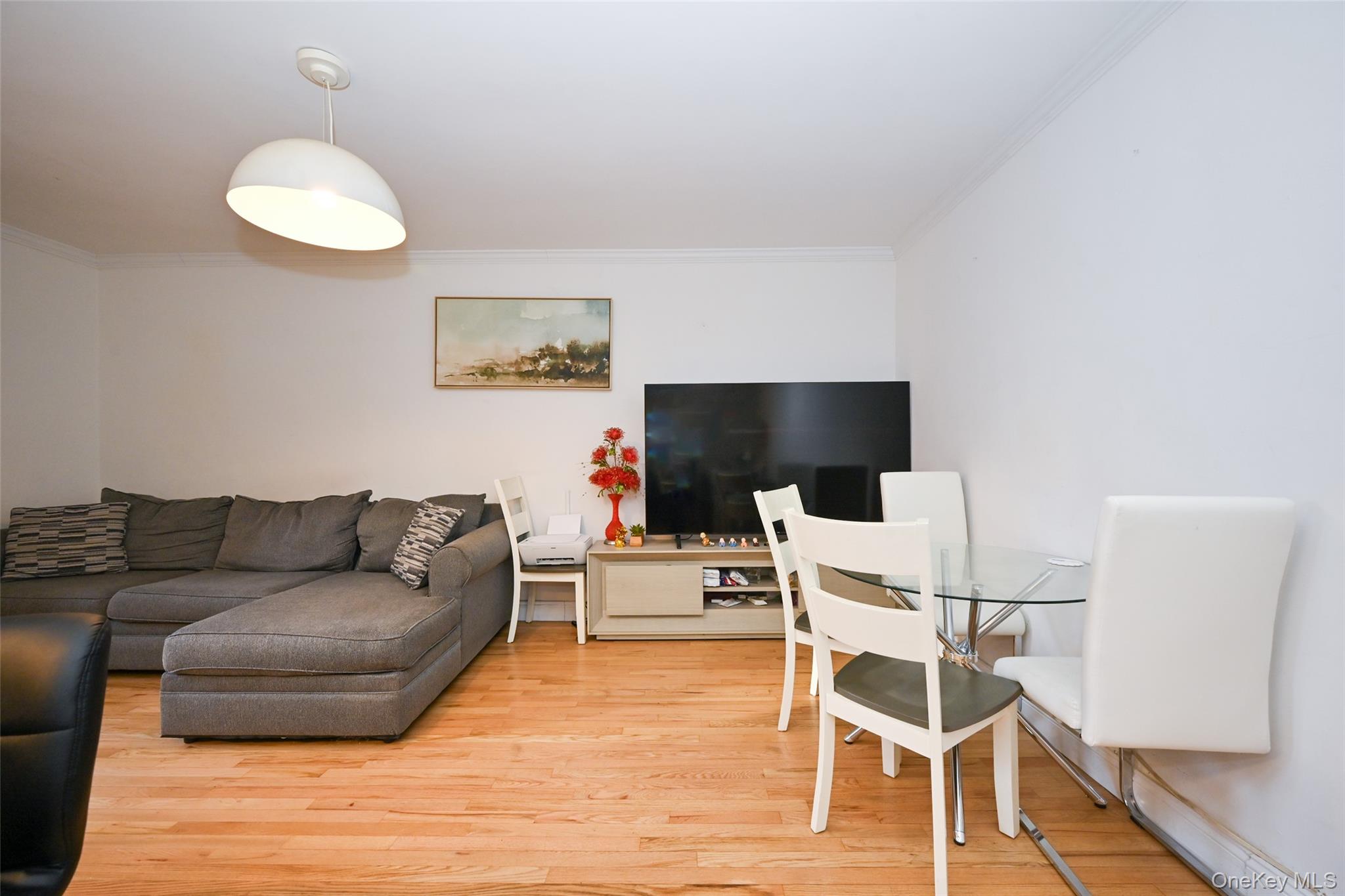 150-30 71st Avenue, Unit 2F Queens, NY 11367 - Photo 8 of 19 Living room featuring crown molding and light wood finished floors