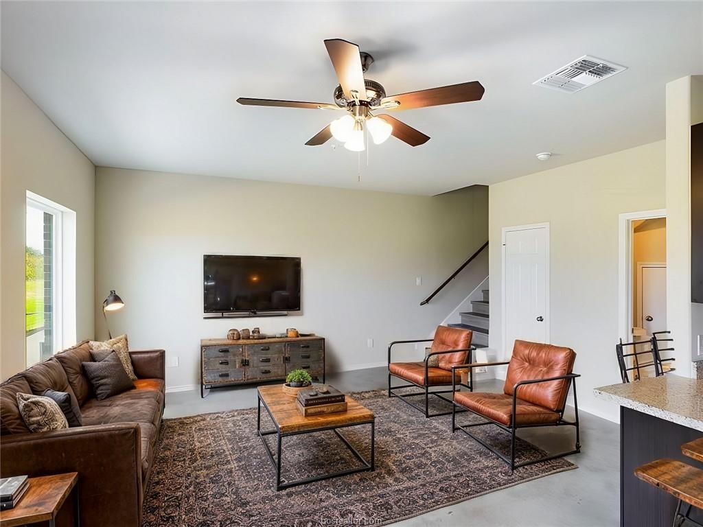 2910 Town Square Avenue, Unit 2103 Bryan, TX 77802 - Photo 2 of 9 a living room with furniture and a flat screen tv with wooden floor