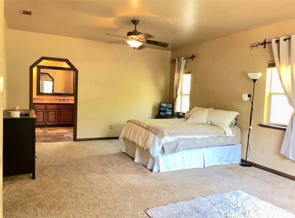 4937 Sweetgrass Lane Bonsall, CA 92003 - Photo 18 of 33 a bedroom with a bed and a chandelier