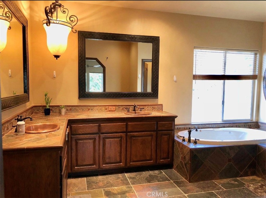 4937 Sweetgrass Lane Bonsall, CA 92003 - Photo 20 of 33 a bathroom with a tub sink and mirror
