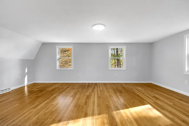a view of empty room with wooden floor