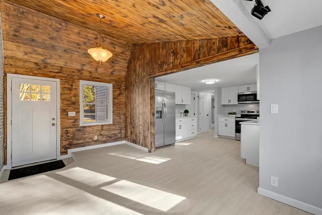 a view of a hallway with closet and a window
