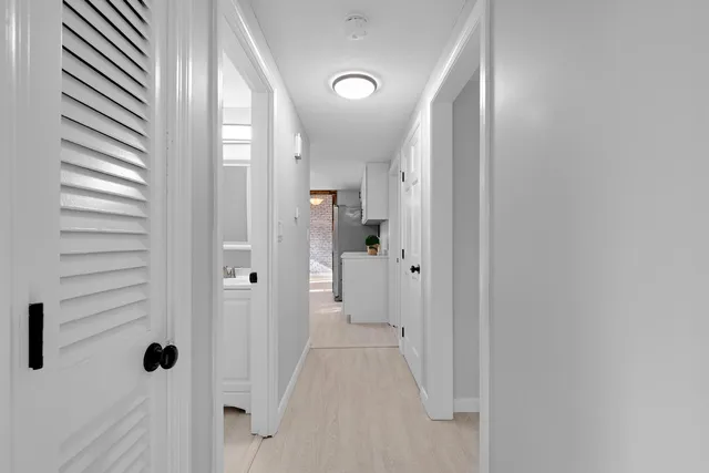 a view of a hallway with wooden floor and closet area