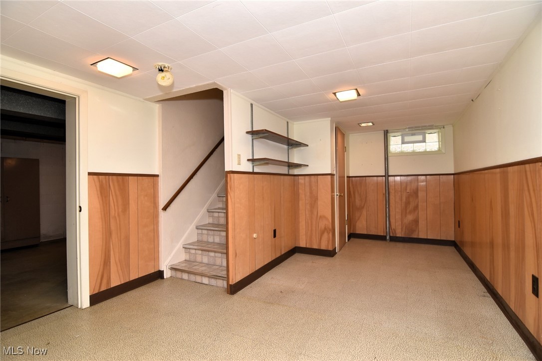 9421 David Road Cleveland, OH 44125 - Photo 29 of 36 Basement featuring a wainscoted wall, stairs, and wooden walls
