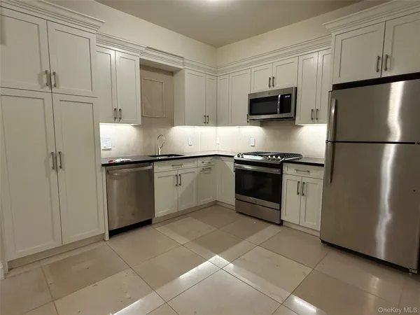 a kitchen with stainless steel appliances a refrigerator sink and microwave