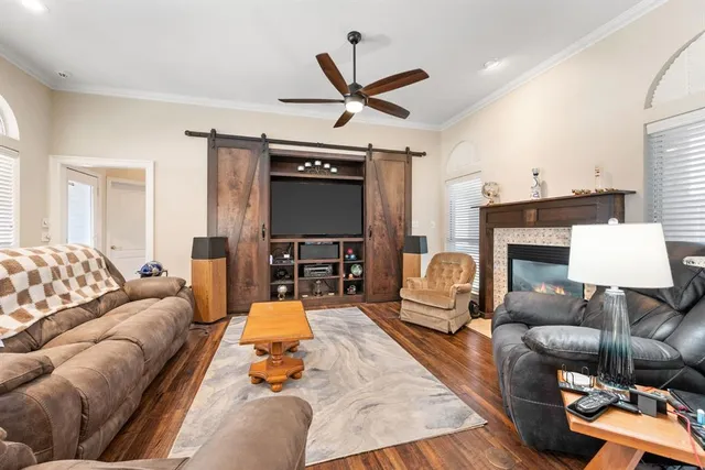 a living room with furniture a fireplace and a ceiling fan